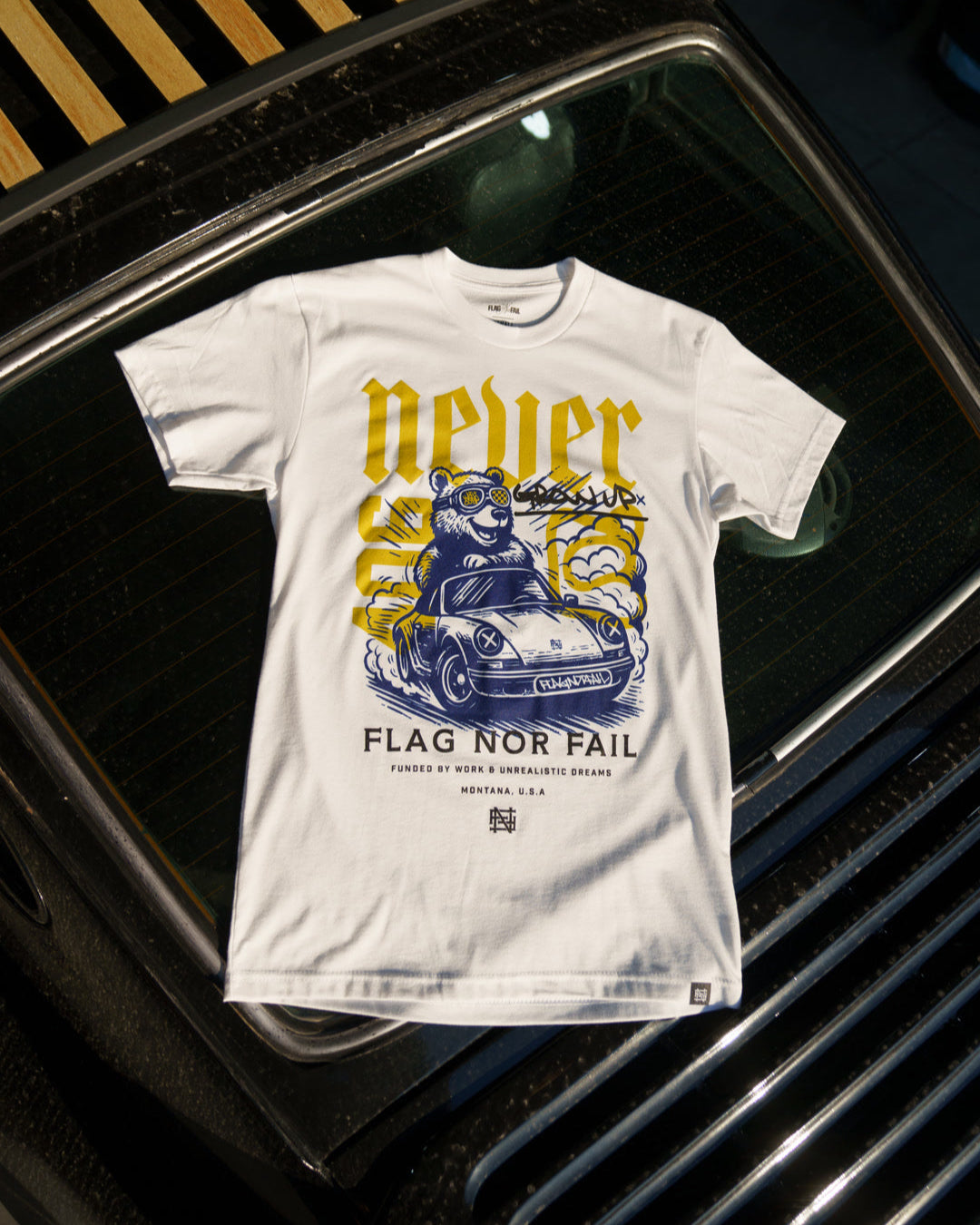 White t-shirt with graphic design and text on a car rear windshield