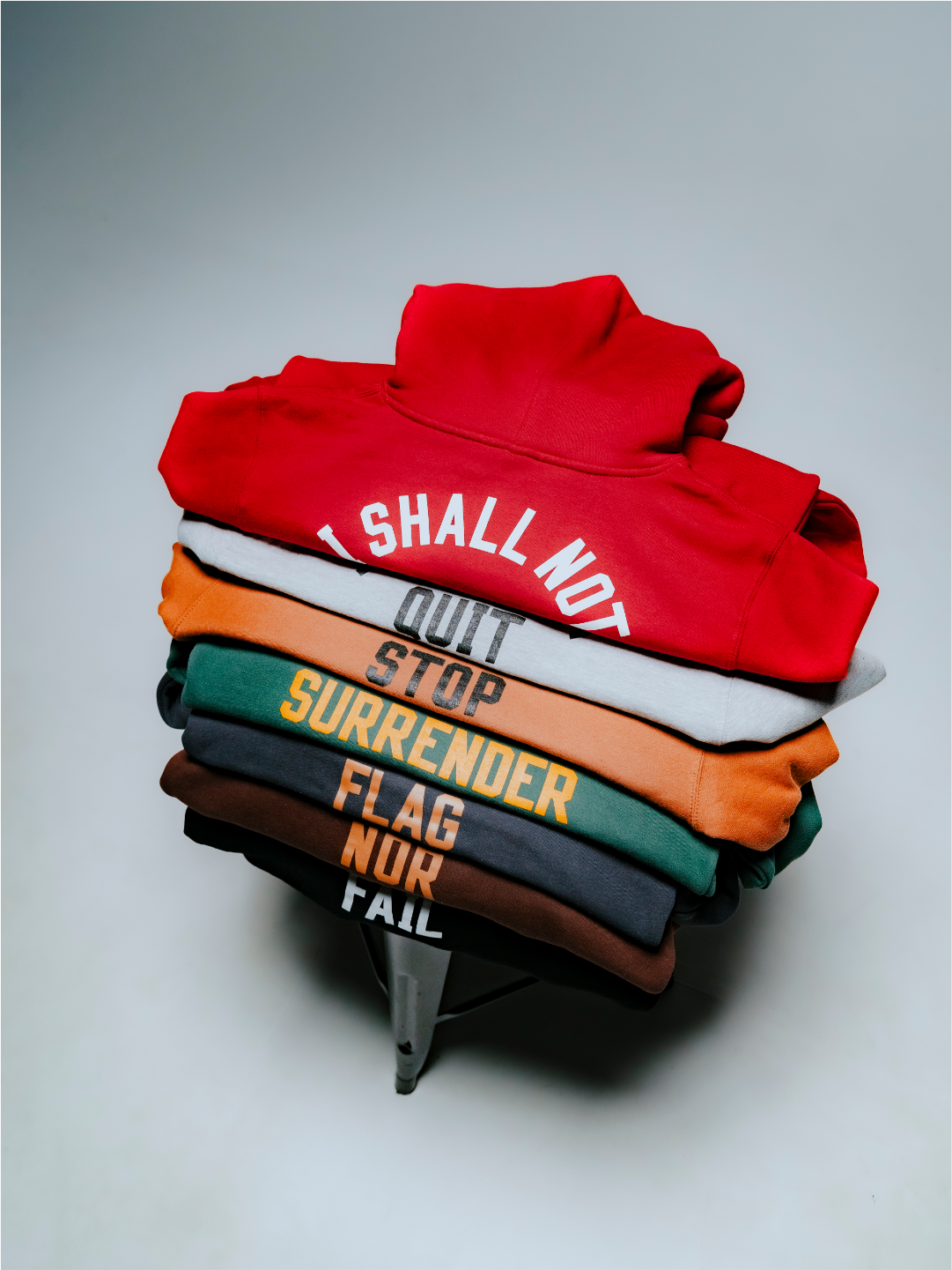 A top down photo of a stack of folded anthem hoodies