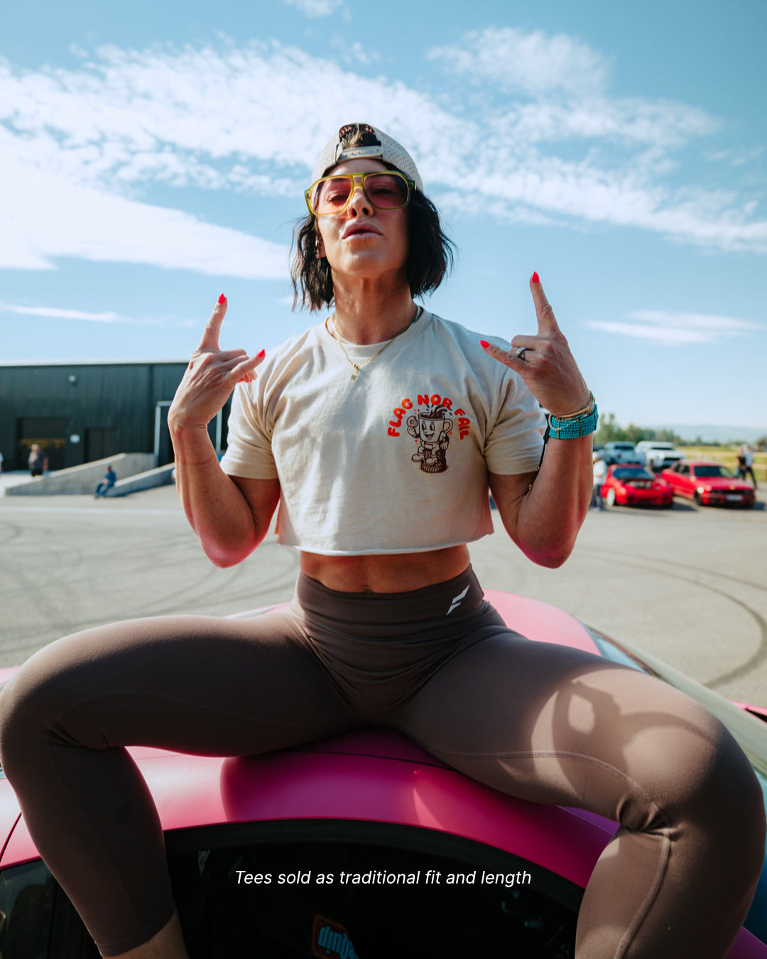 Person sitting on a pink car with a clear blue sky in the background