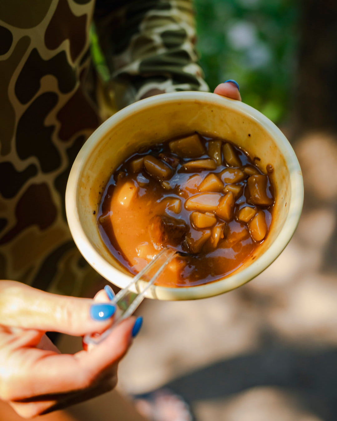 Holding ceramic bowl full of soup