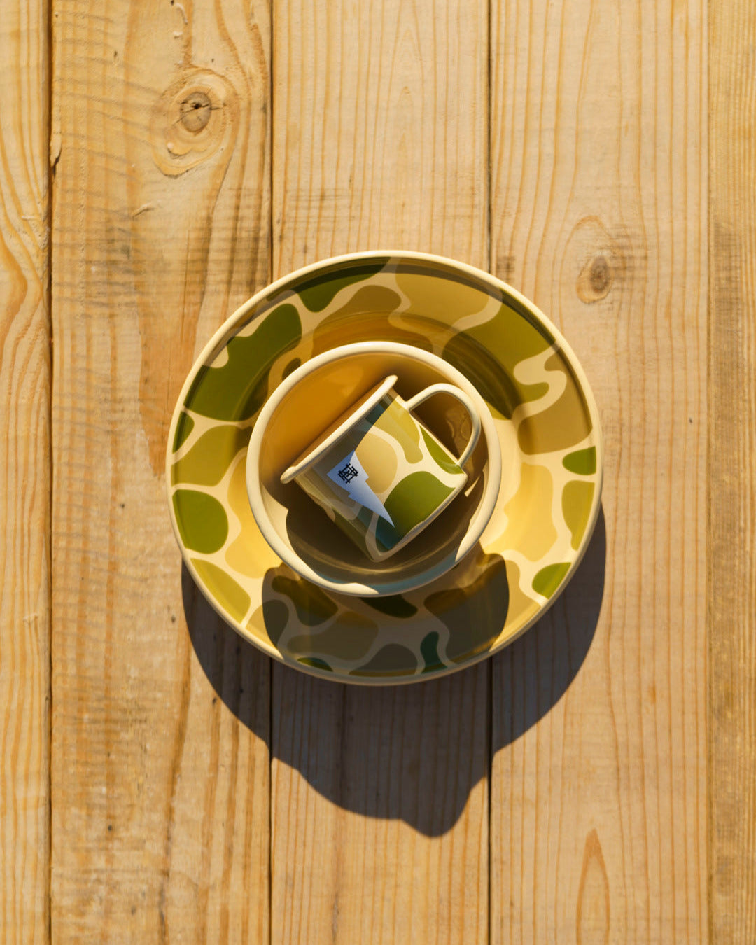 Ceramic bowl with a green and brown camo pattern on a wooden surface