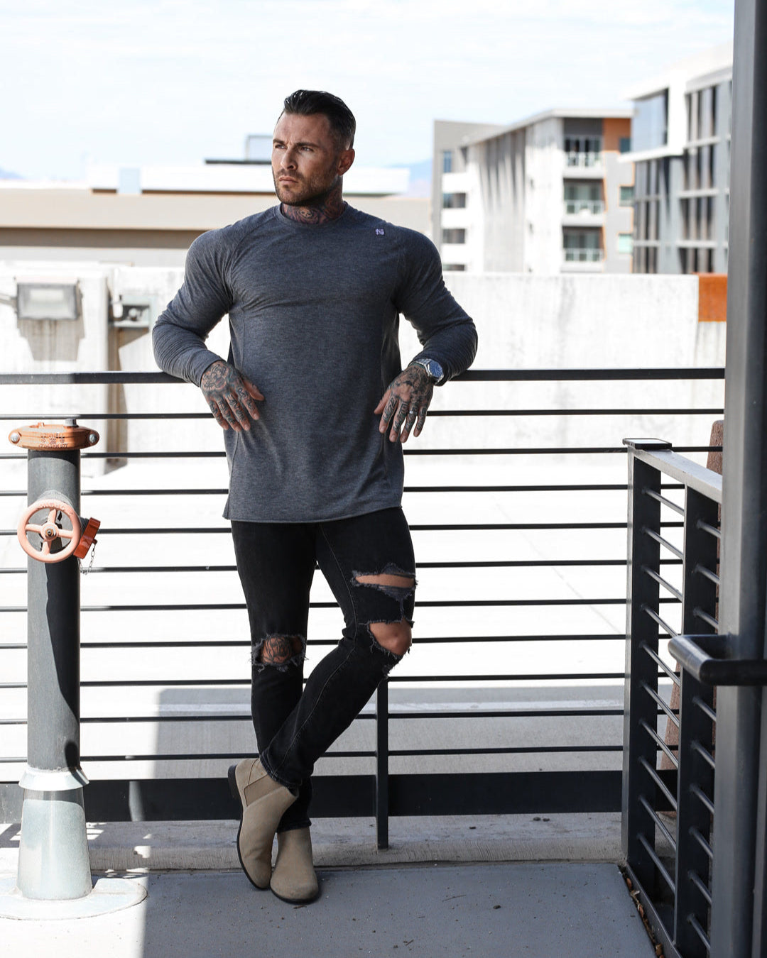Man standing on a rooftop with modern buildings in the background