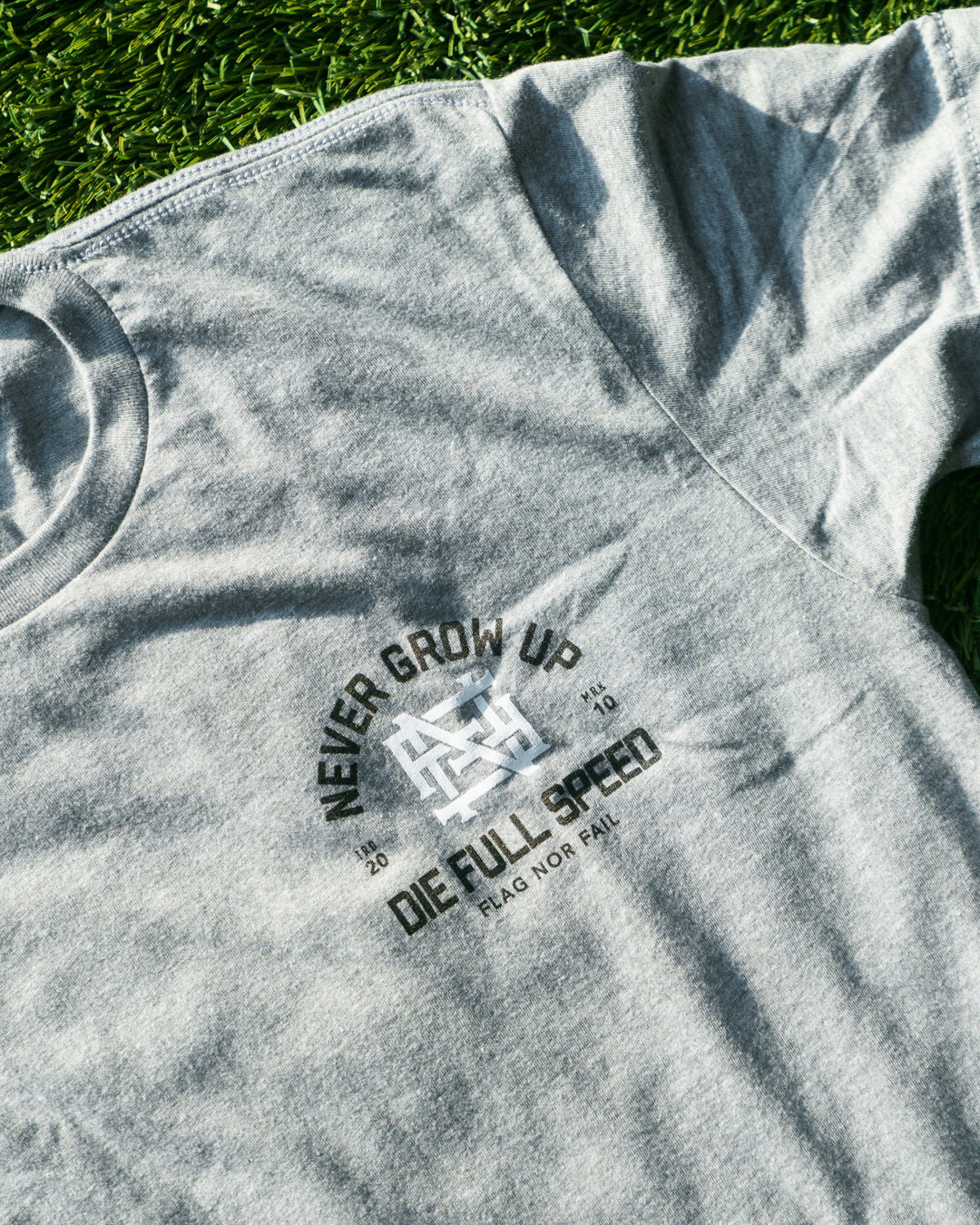 Gray t-shirt with a graphic design on a grass background